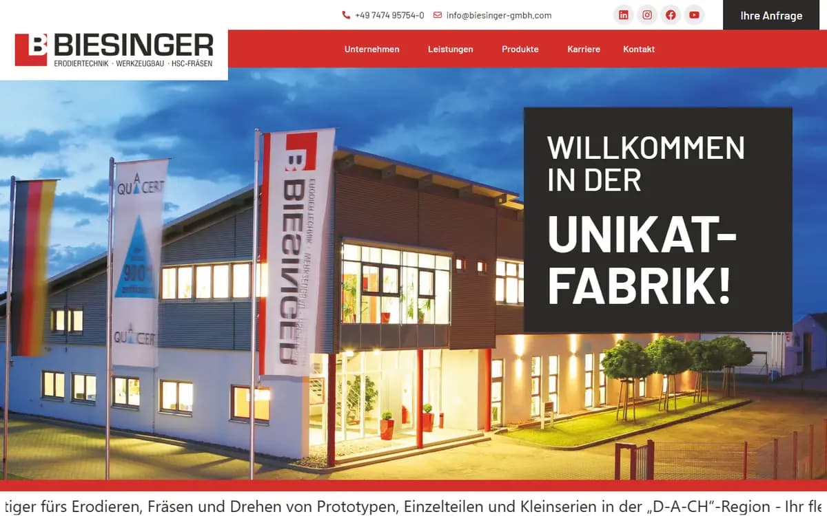 Startseite der Biesinger GmbH mit Firmengebäude am Abend und dem Claim Willkommen in der Unikat-Fabrik